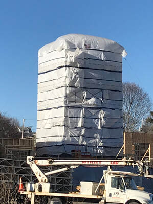 Elevator tower wrapped in building wrap